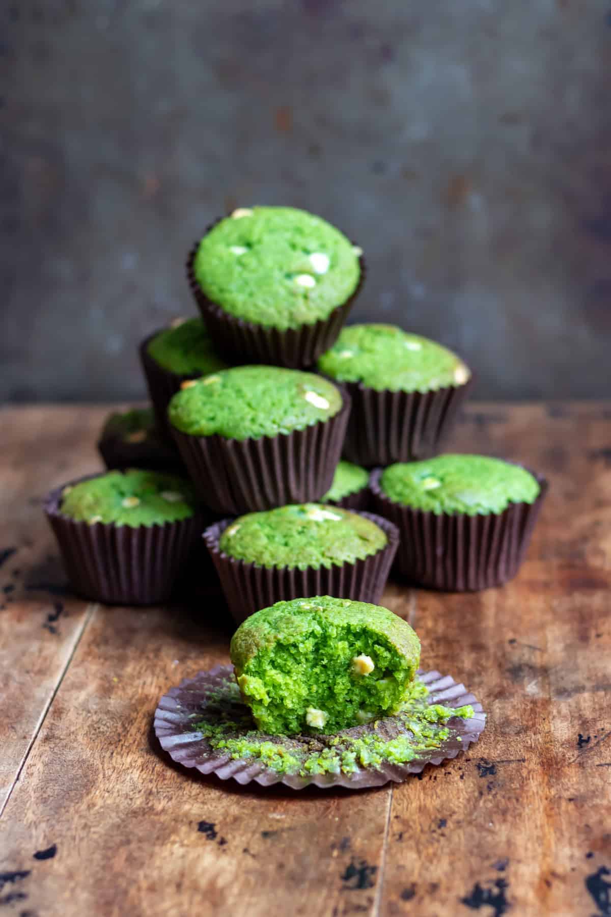 Stack of Lemon Spinach muffins, plus one with a bite out.