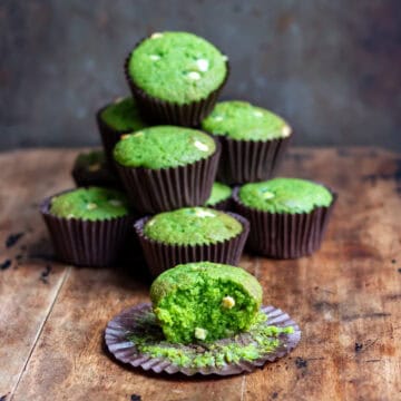 Stack of Lemon Spinach muffins, plus one with a bite out.