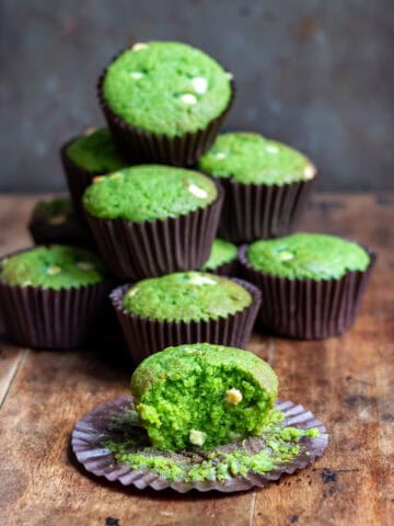 Stack of Lemon Spinach muffins, plus one with a bite out.