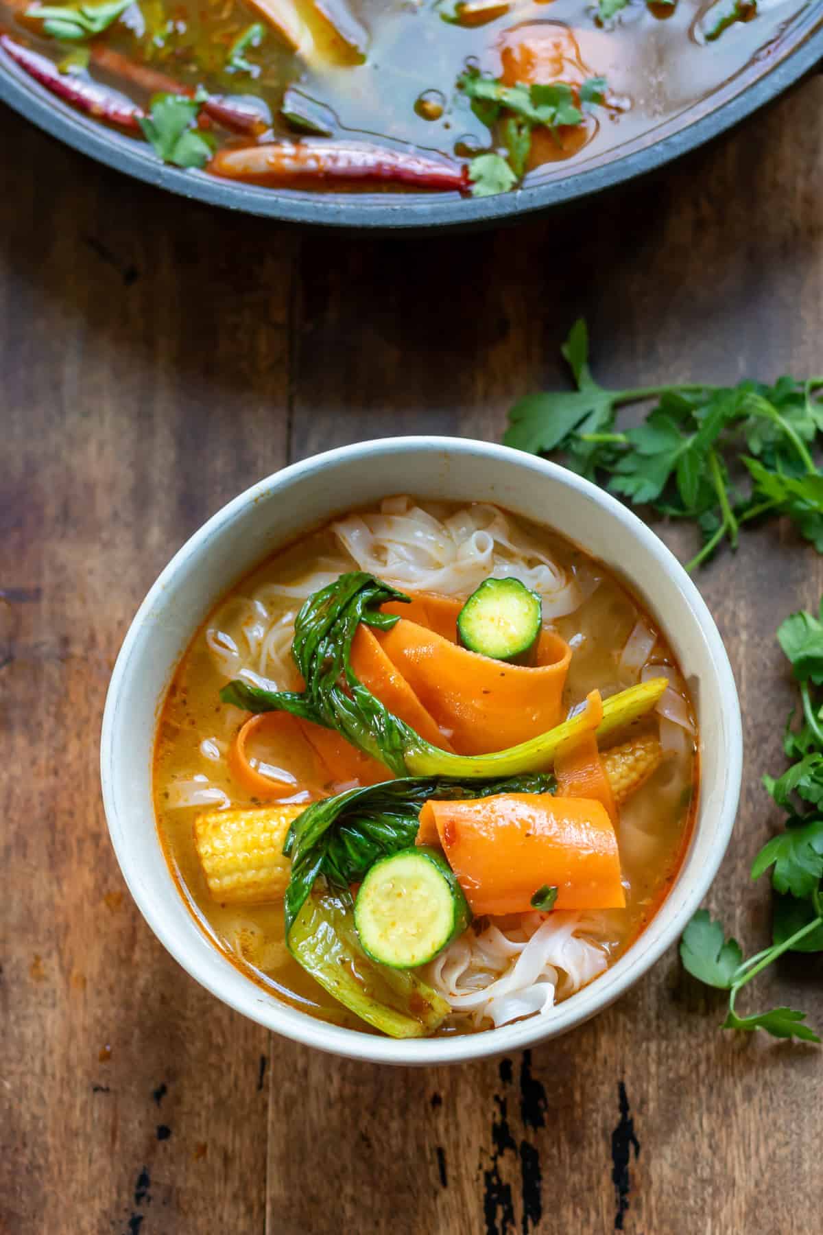 A bowl with the rice noodles and thai vegetable soup.