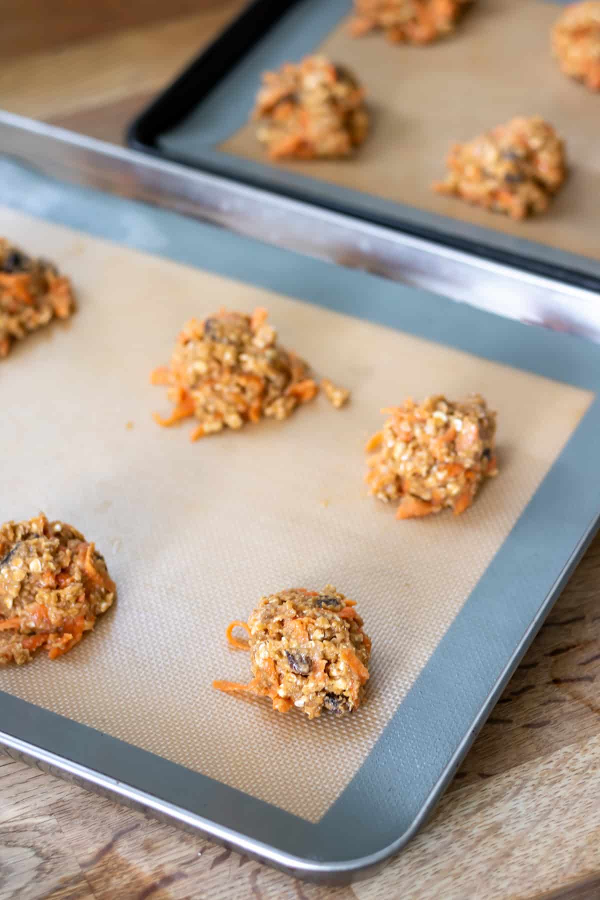 Scoops of cookie dough on baking trays.