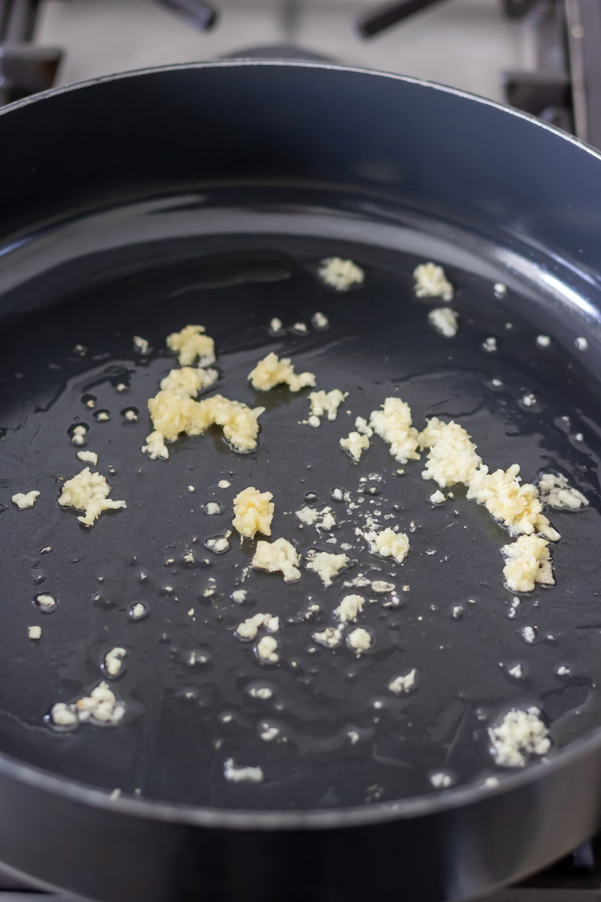 Garlic cooking in oil in a pan.