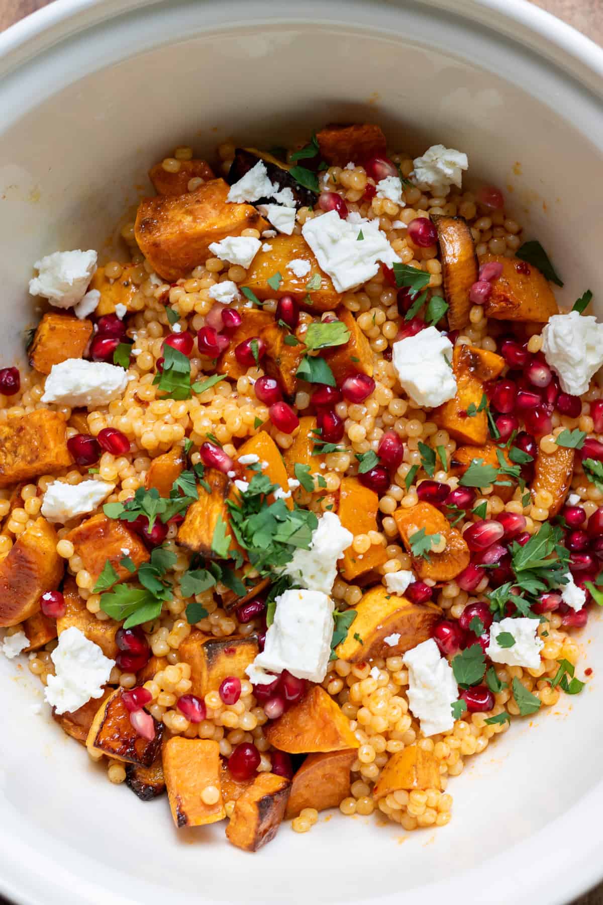 Feta, pomegranate seeds and parsley added to the bowl.