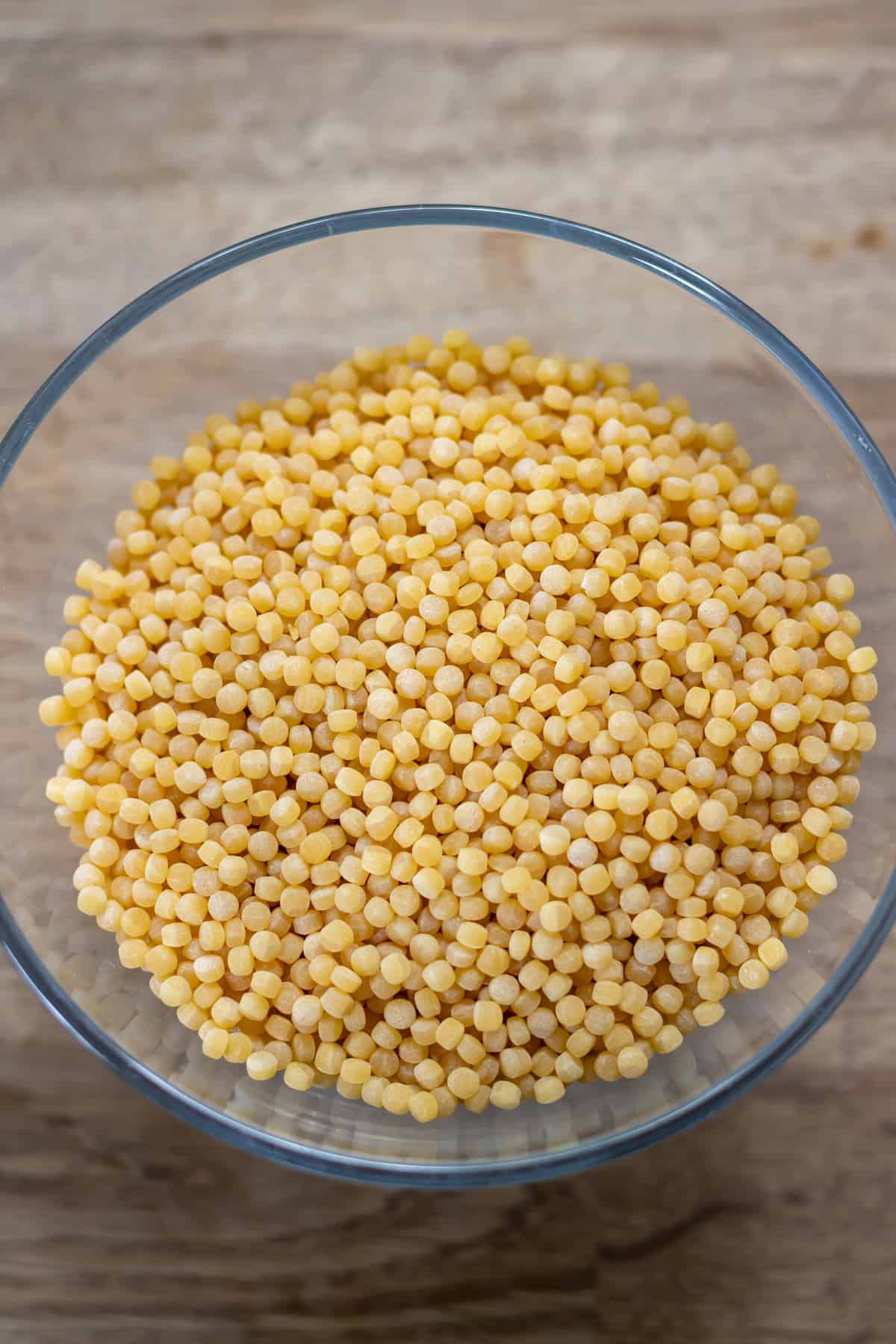 Bowl of uncooked giant pearl couscous.