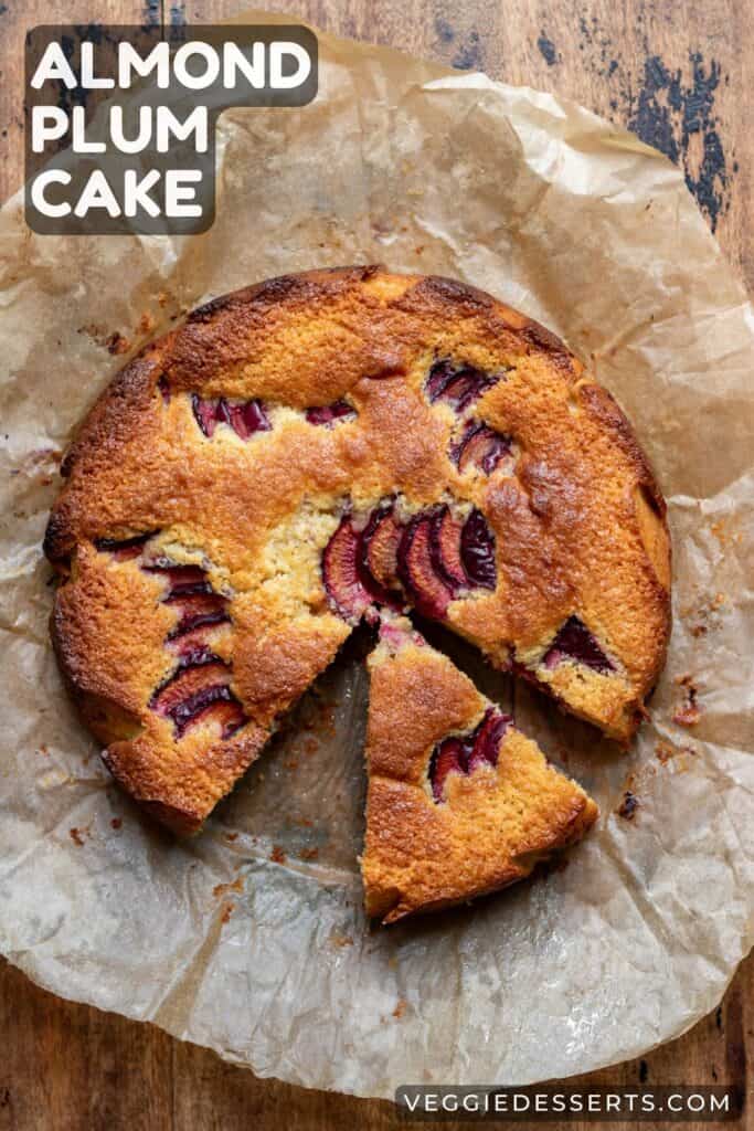 A cake with a slice out, with text: Almond Plum Cake.