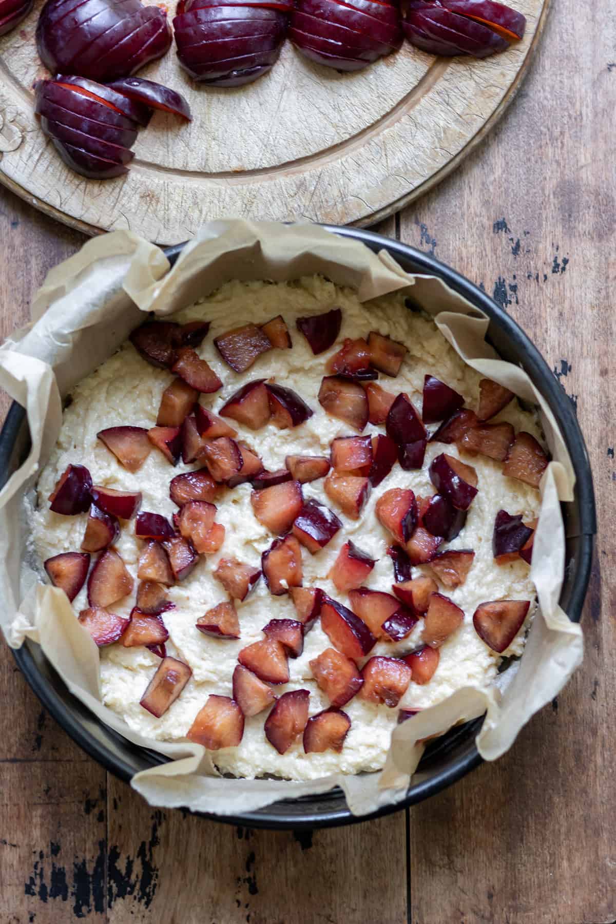 Half of the batter spread into the prepared cake pan, then sprinkled with the chopped plums.