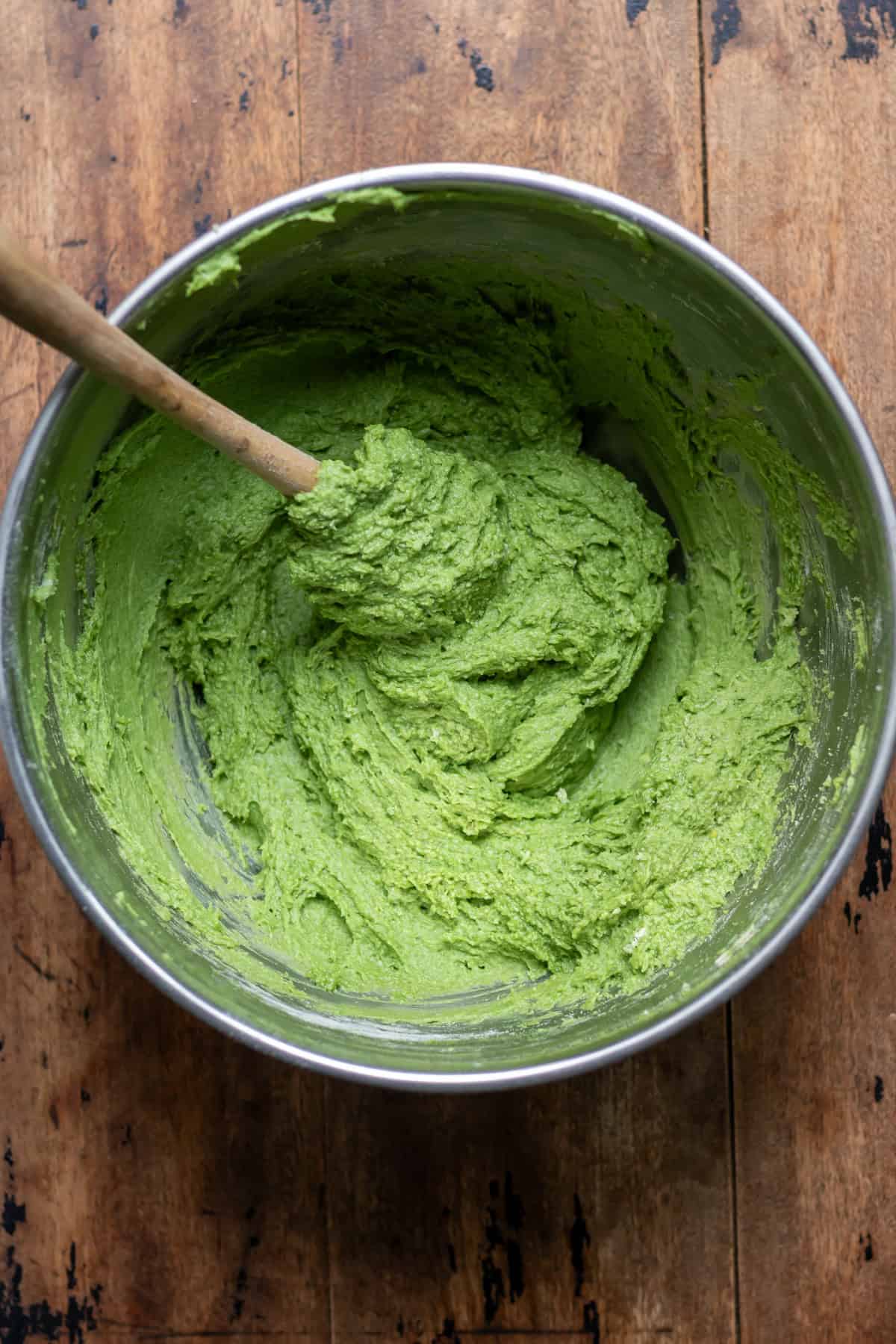 Bright green stinging nettle cake batter in a mixing bowl.