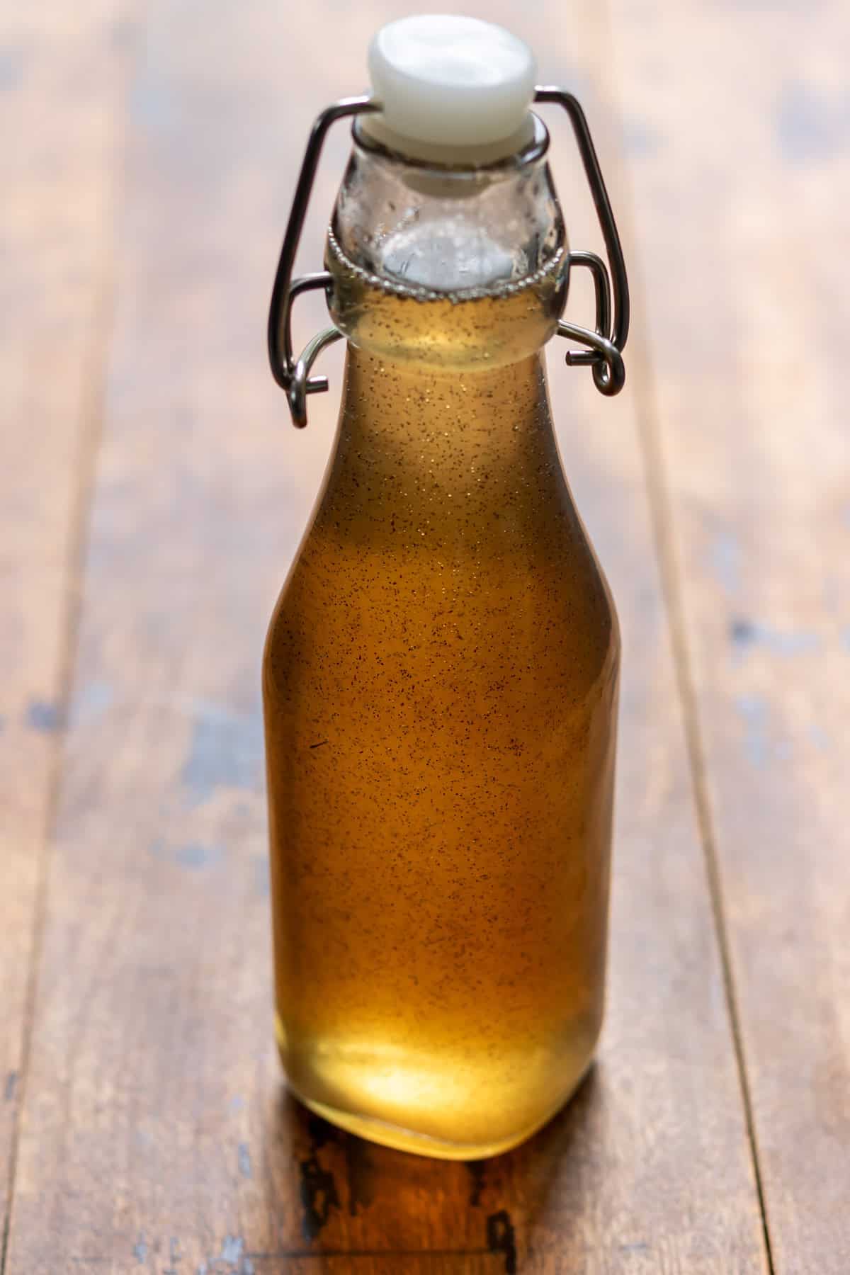 A glass bottle of vanilla syrup on a table.