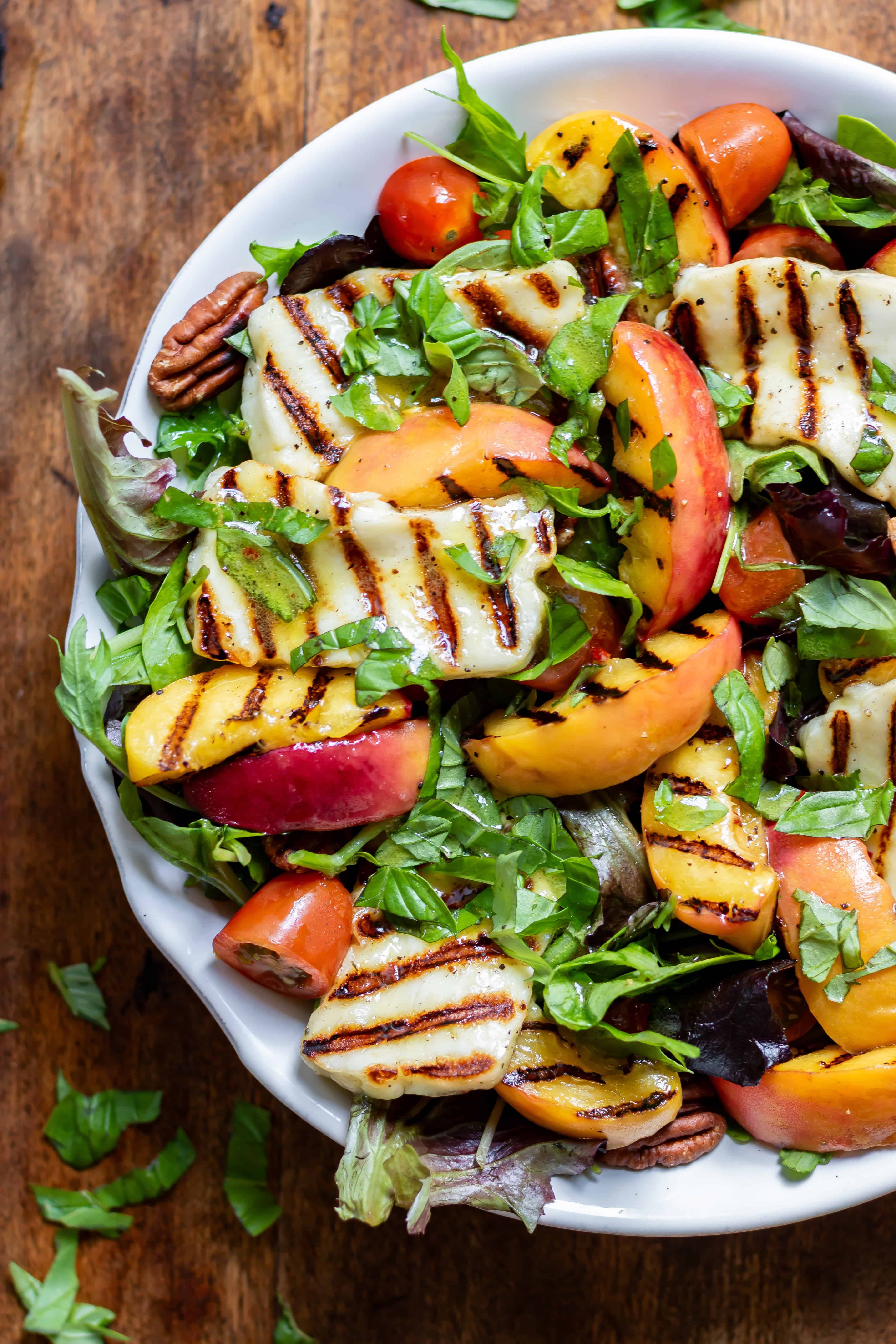 Close up of a serving dish of hot honey grilled halloumi peach salad.