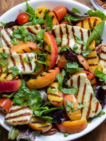 A serving dish of hot honey grilled halloumi peach salad.