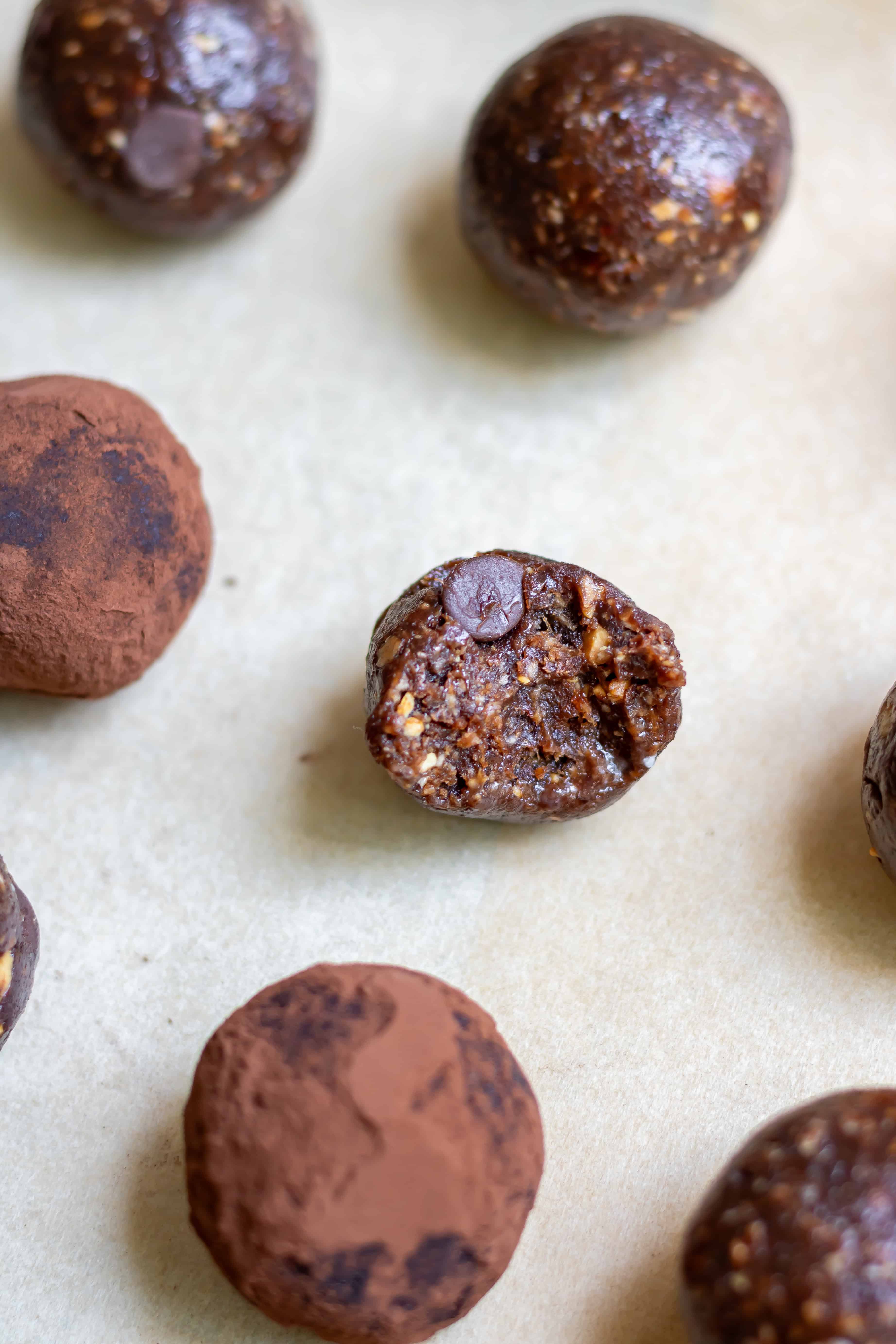 Close up of a chocolate brownie energy ball with a bite out.