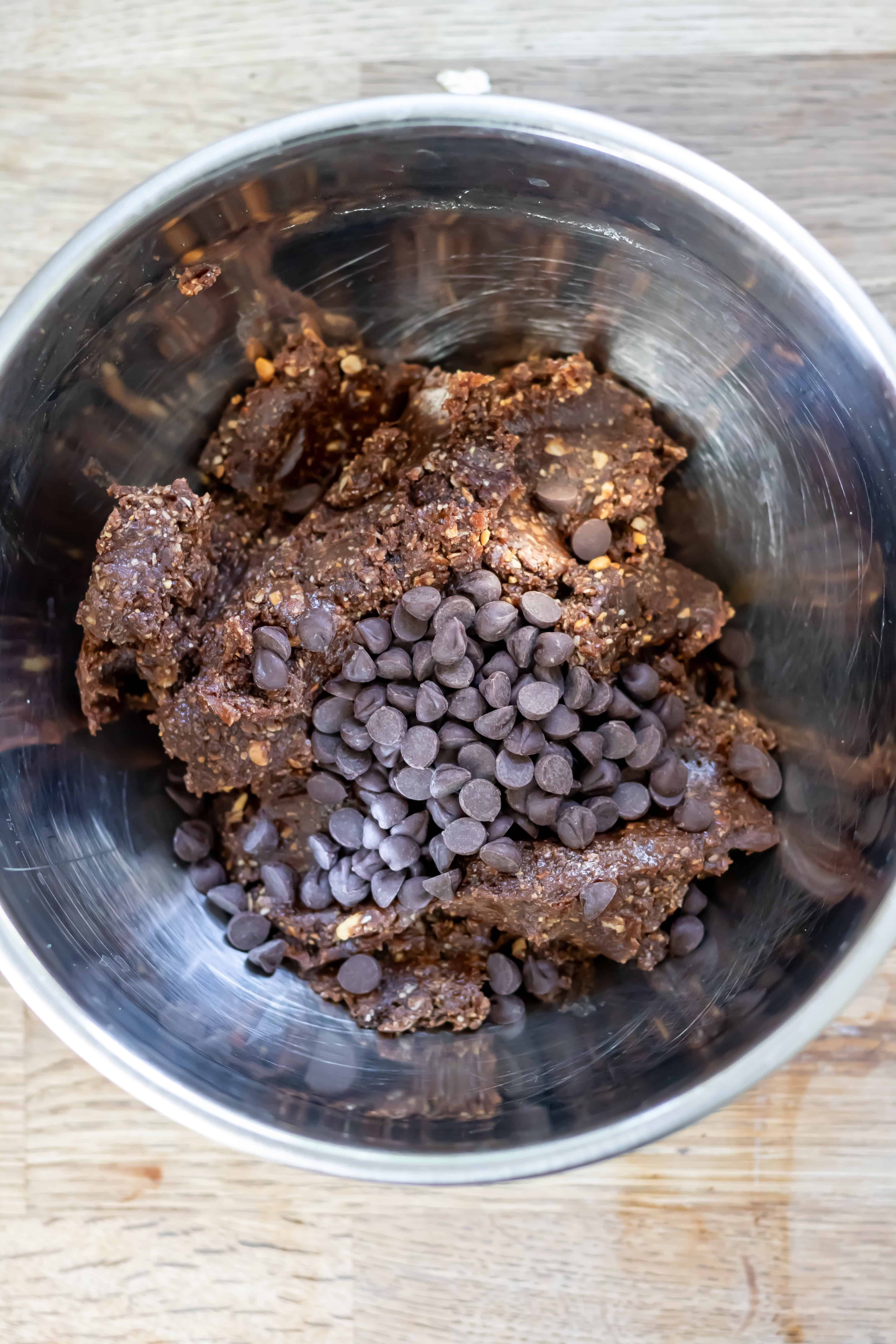 Brownie energy ball mixture in a bowl with the chocolate chips.