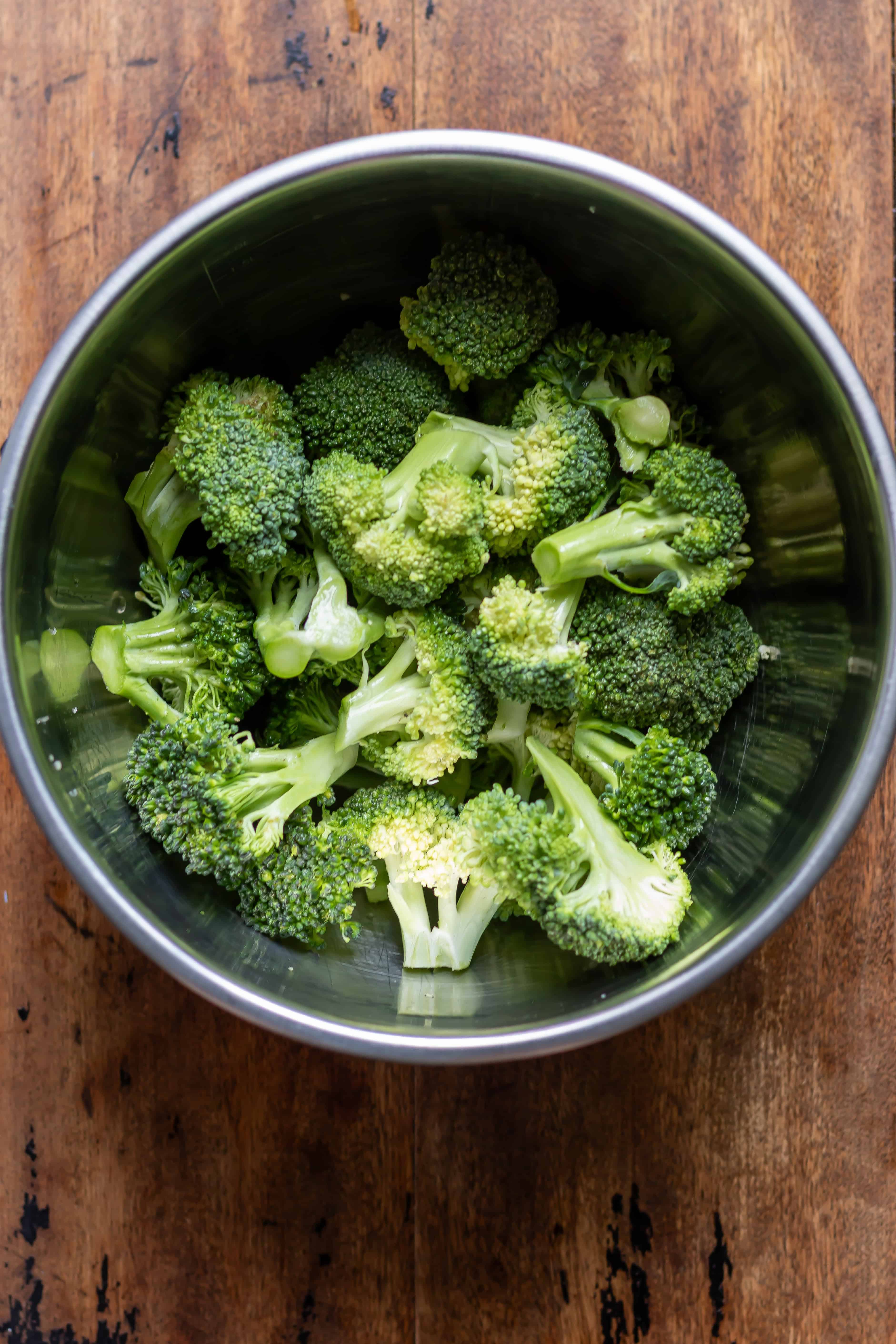Broccoli florets and oil in a bowl.