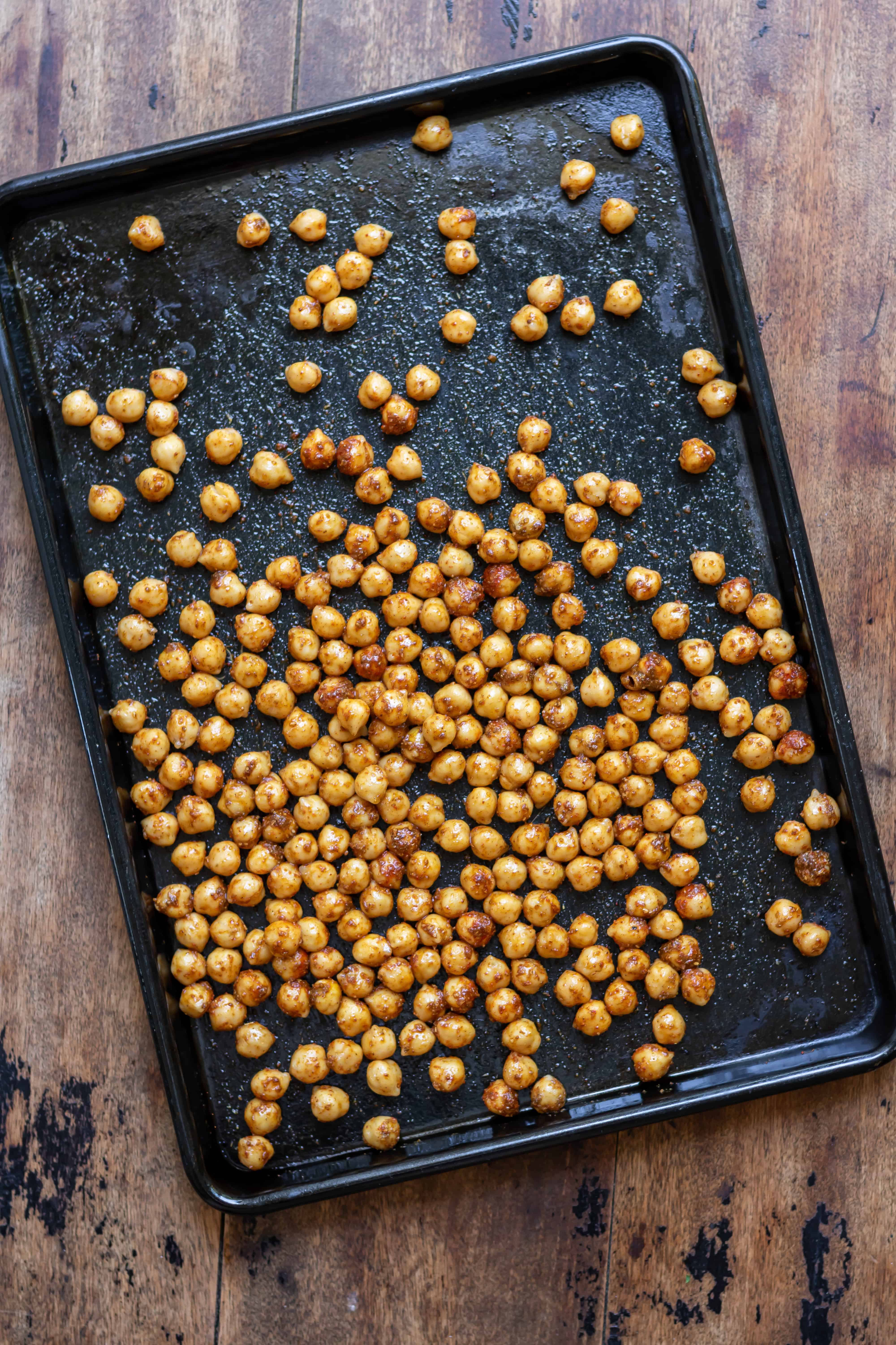 Coated chickpeas on a baking sheet.