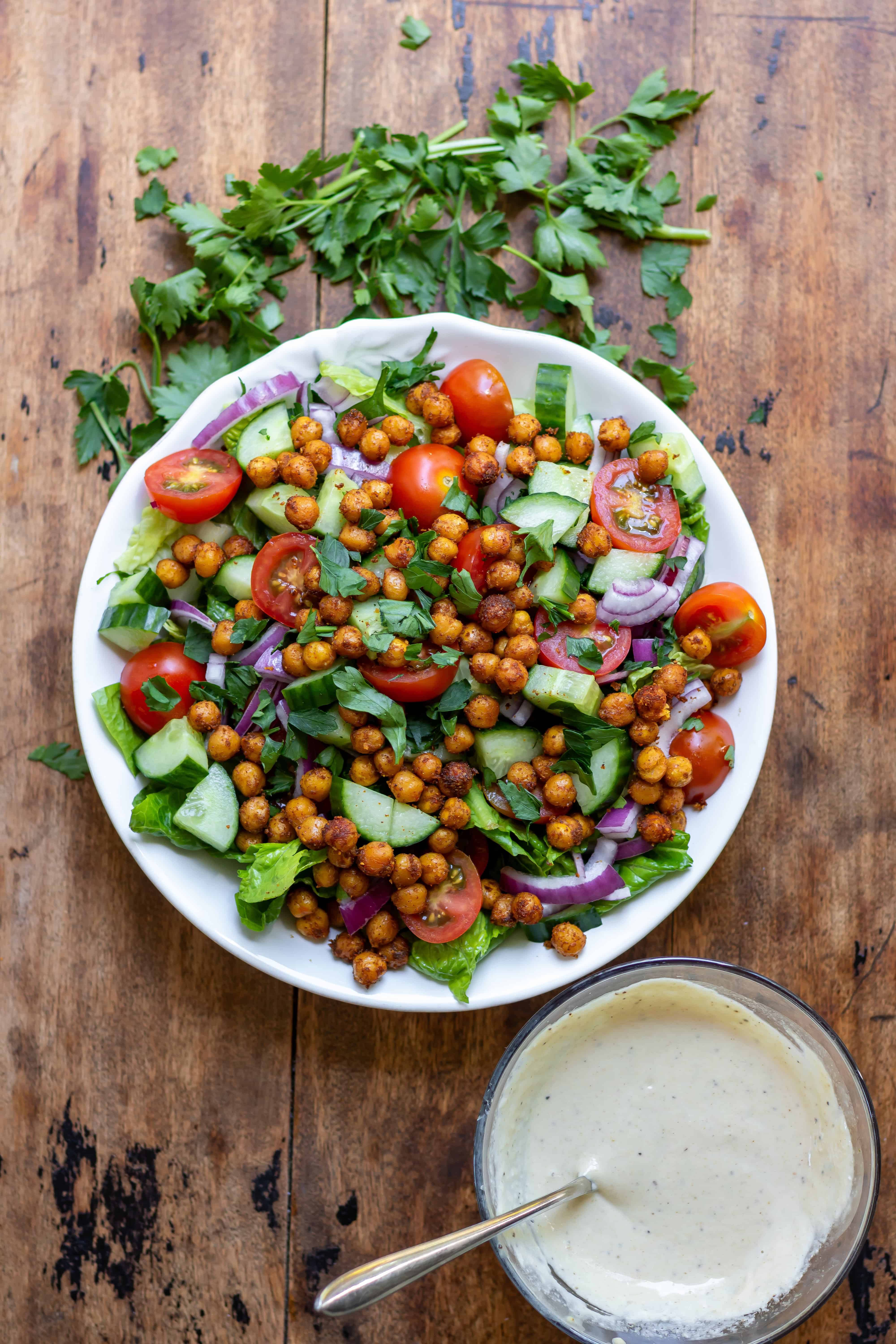 Salad, vegetables, shawarma roasted chickpeas in a serving dish.