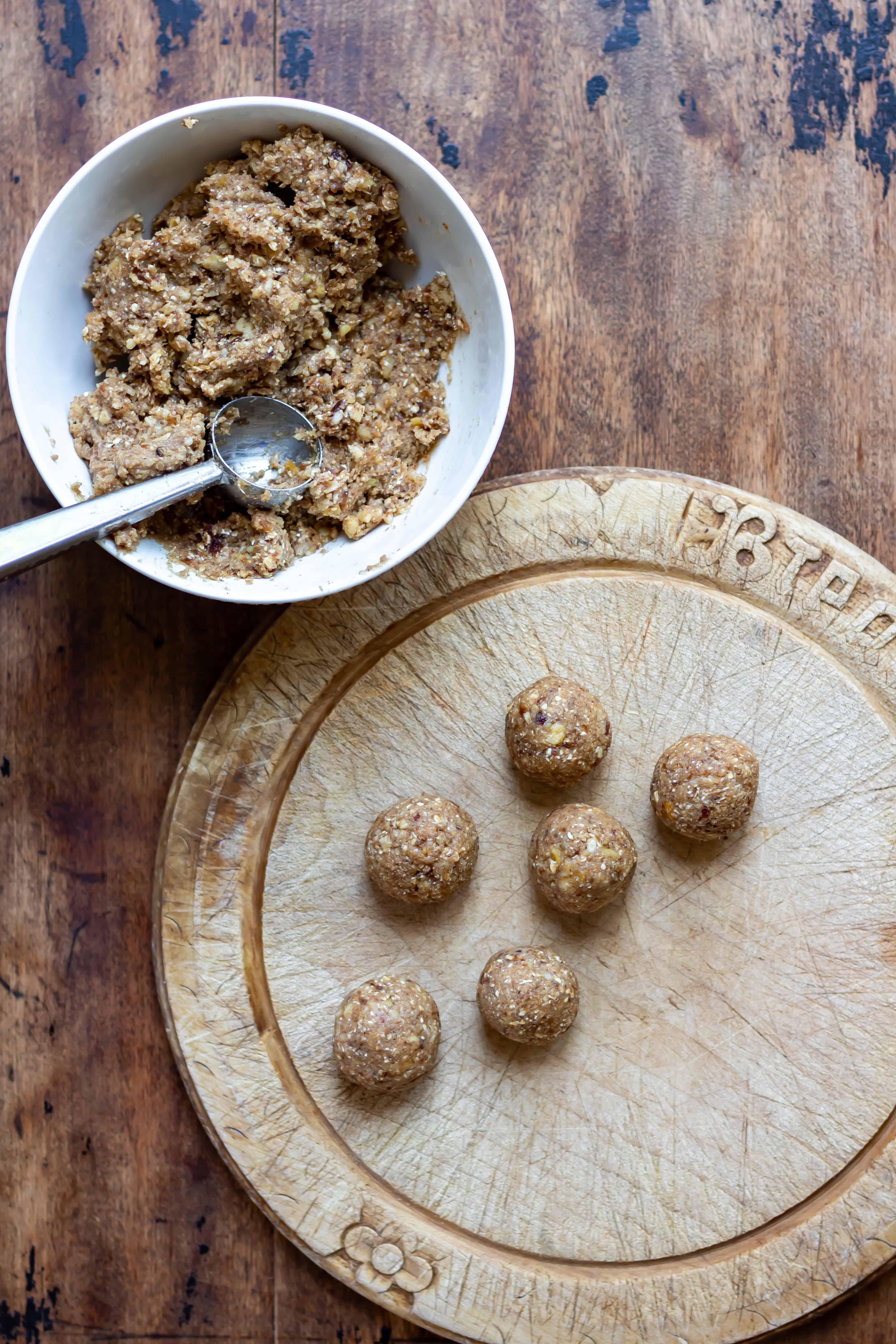 Scooping small balls of the mixture and rolling them then placing onto a cutting board.