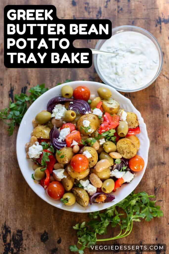Dish of roasted potatoes and vegetables with text: Greek Butter Bean Potato Tray Bake.