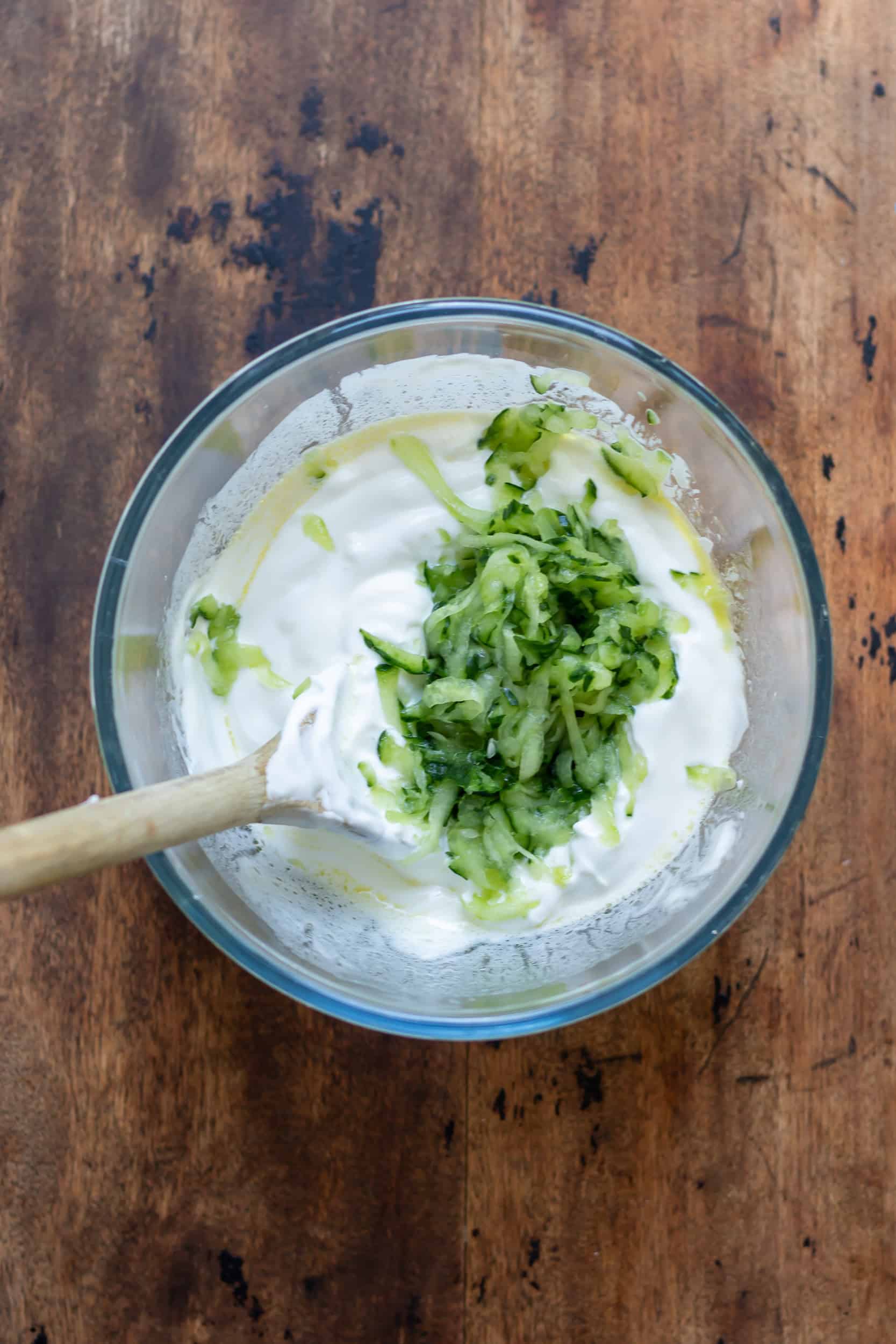 Strained shredded cucumber in the bowl of yogurt.