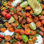 Close up of Mexican Chipotle Sweet Potato and Black Bean bake with limes and avocado.