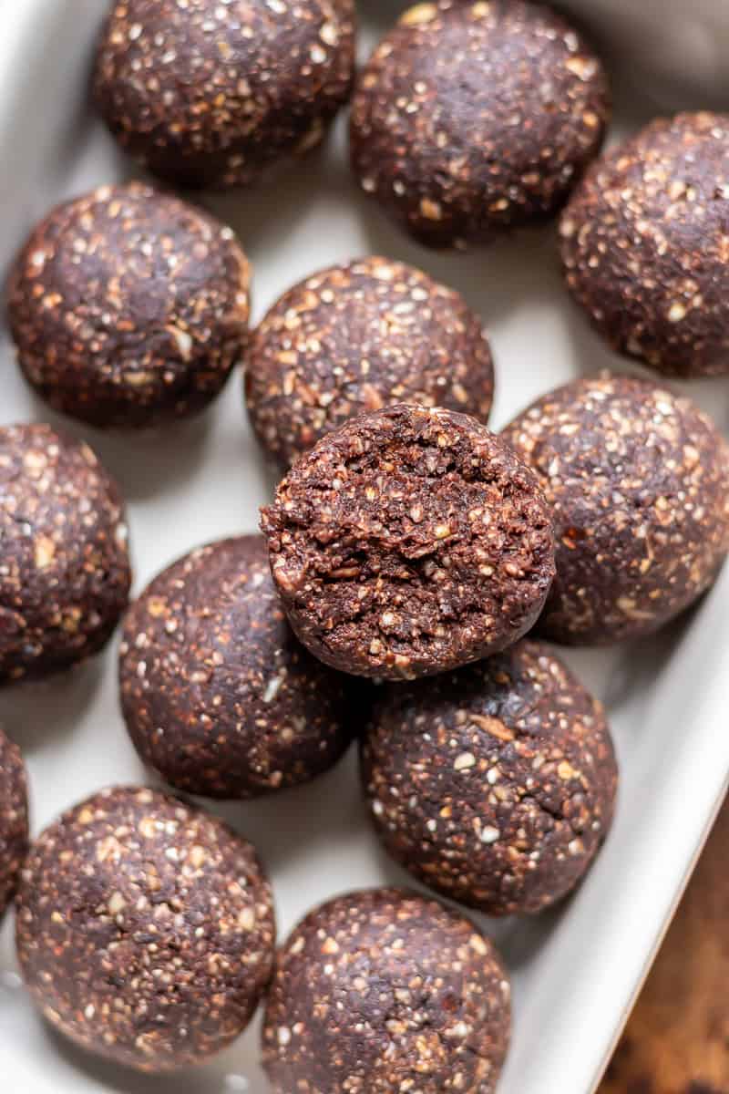 Dish of mint chocolate energy balls with one on top with a bite out.