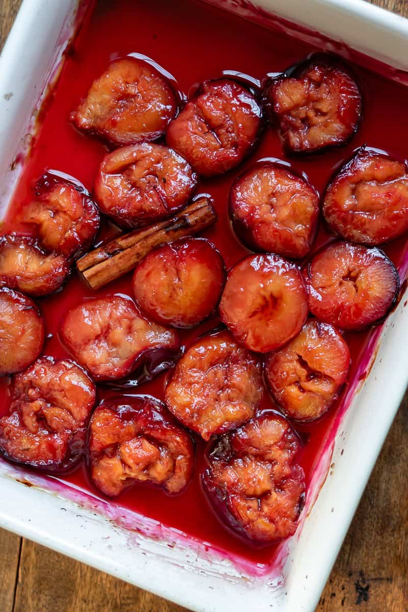 A ceramic dish of roasted plums.