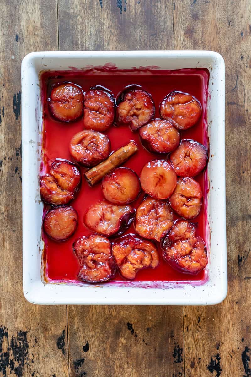 Roasted plums in a baking dish.