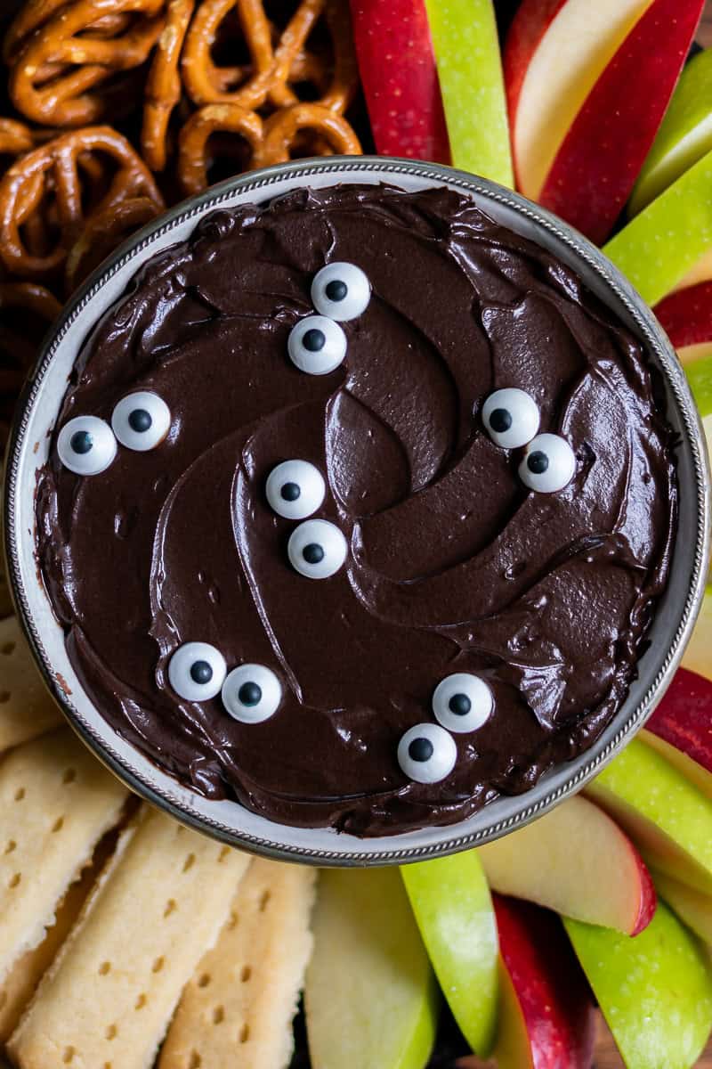 Close up of Halloween black cocoa cheesecake dip with candy eyes.